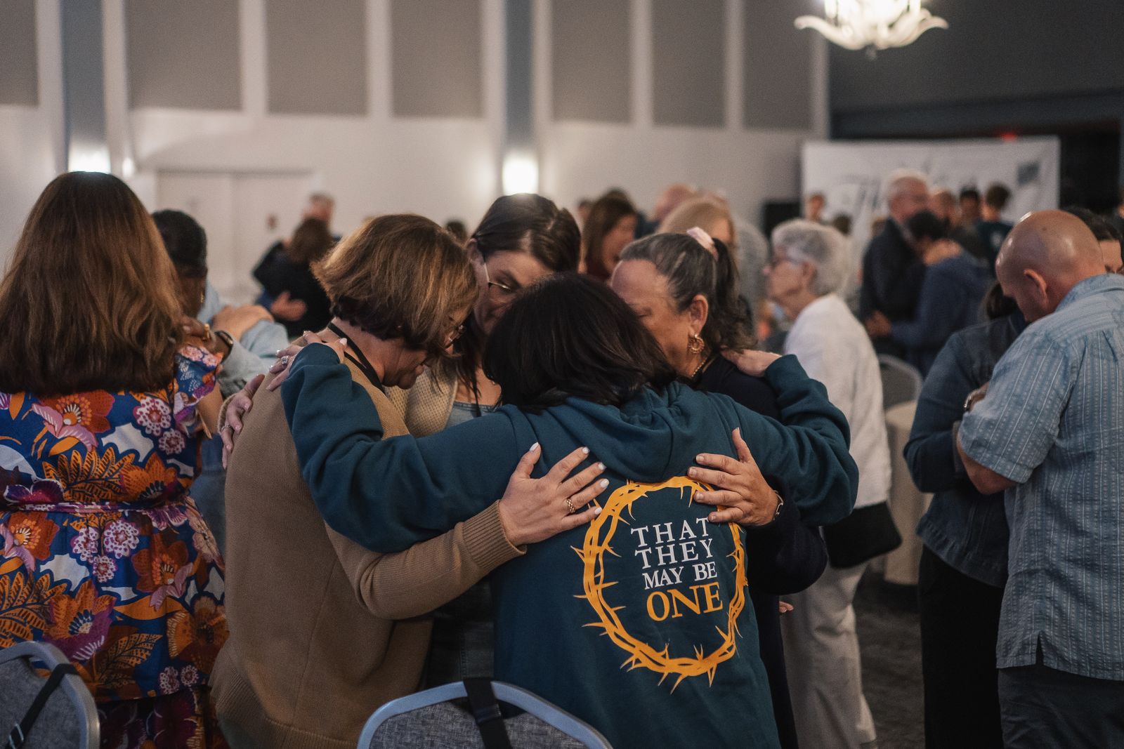 Conference attendees embracing in prayer